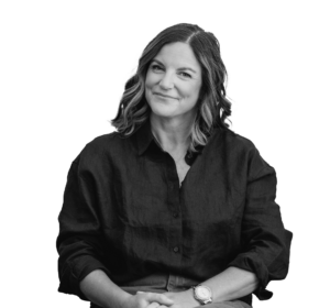 Black and white photo of Jenny Mitchell looking at the camera with her hands folded in her lap